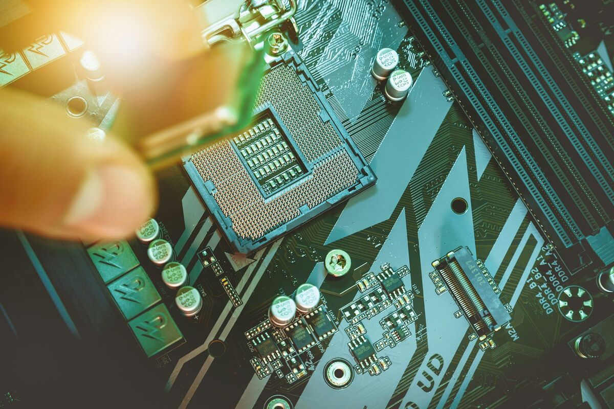 Técnico instalando un procesador sobre la placa madre de una computadora