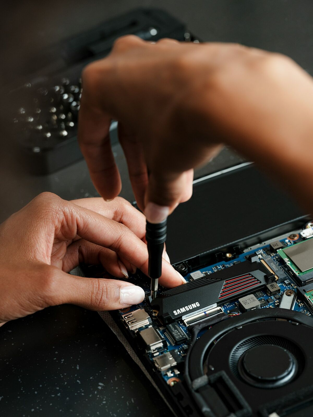 Técnico reparando una laptop con destornillador